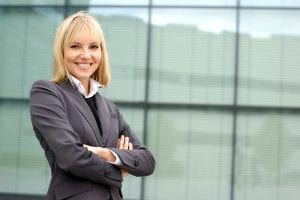 A smiling woman in a business suit representing a property manager.