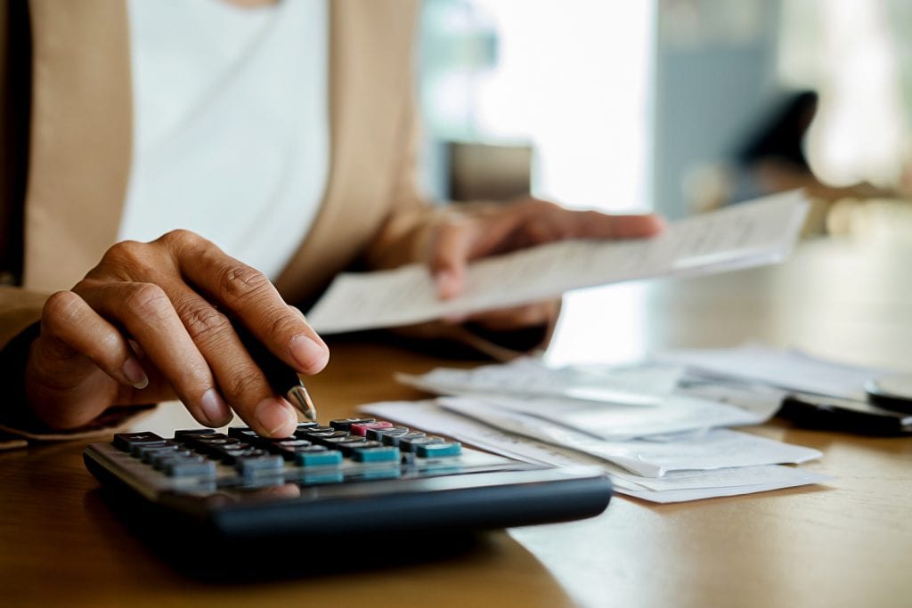 A woman calculating bills for Salt Lake City property management.